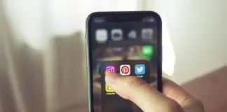 person holding mobile phone with social media open