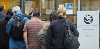 people queing to collect unemployment benefit
