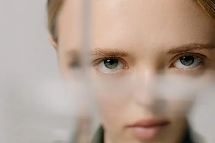 pexels-cottonbro-5876883 woman with face distorted as looking partially through glass
