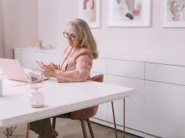 lasy in pink working from home office olooking at mobile phone