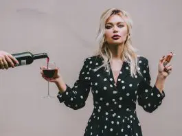 woman in spotted dress with cigarette and wine