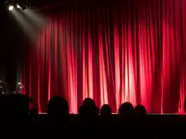 spotlight on empty stage with red curtain
