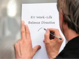 man writing notice on sheet of paper