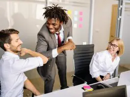 3 office workers, 2 of them elbow bumping greeting