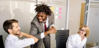 3 office workers, 2 of them elbow bumping greeting