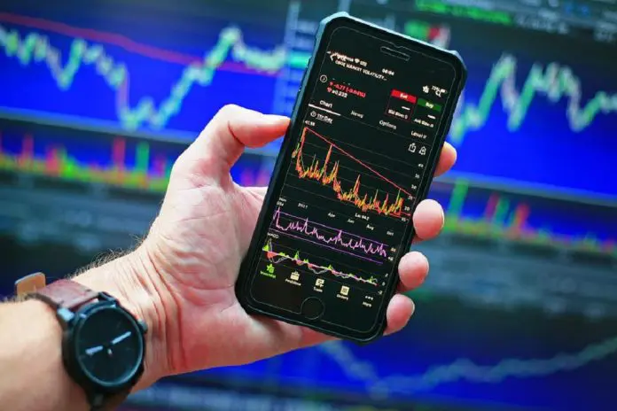 Information and Communications Technology sector person holding phone displaying information graph