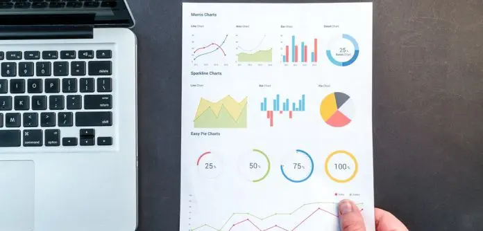 pexels-lukas-669612 various charts on a page beside a laptop