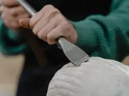 person chiselling sculpture