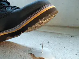 accident about to happen with boot stepping on nail