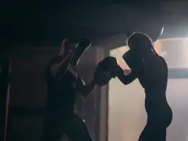 femal boxer with male coach working pads