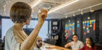 lady leading team through plan on clear whiteboard