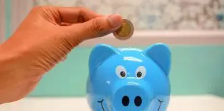 person putting money into piggy bank