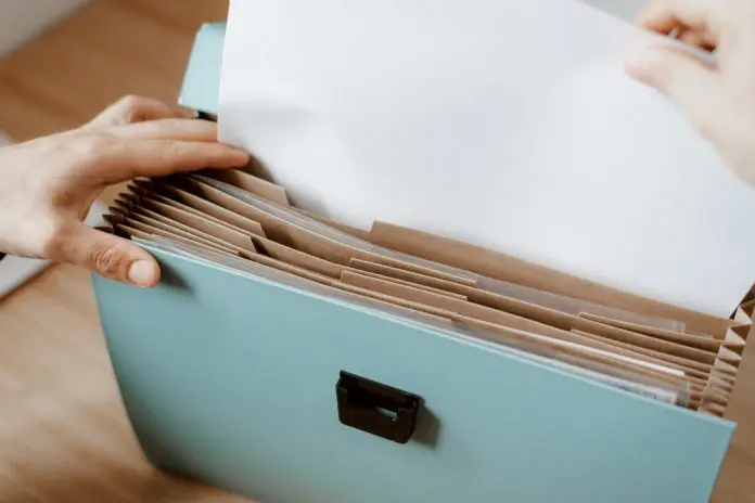 hand placing document in file