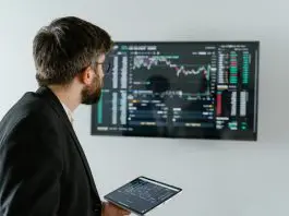 man in office looking at HR statistics on computer
