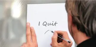 man writing note on paper