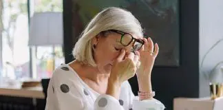 woman in front of laptop rubbing sore eyes