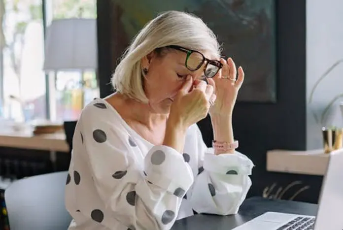 HRHQ Sore eyes woman in front of laptop rubbing sore eyes