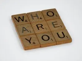 wooden scrabble tiles spelling out "who are you" in a square 3x3