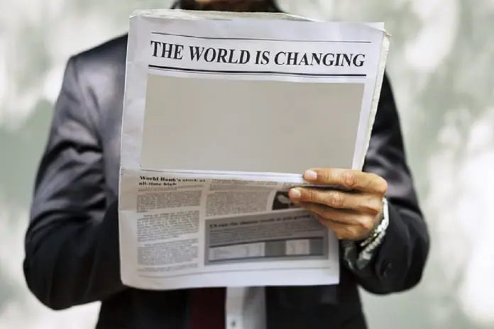 newspaper with headline reading the world is changing