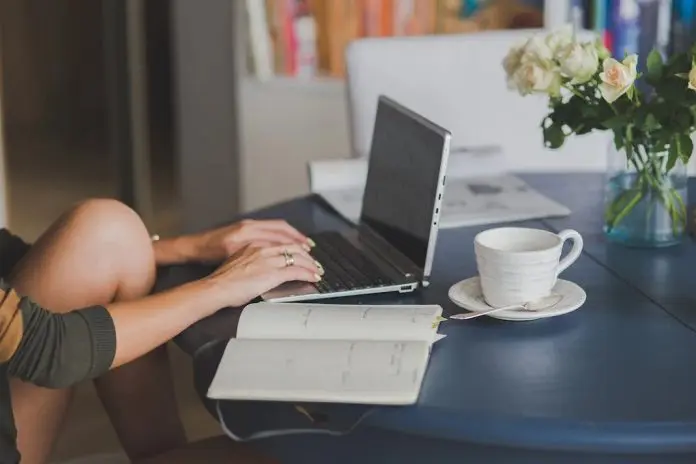 HRHQ Work from home woman working from home at laptop on kitchen