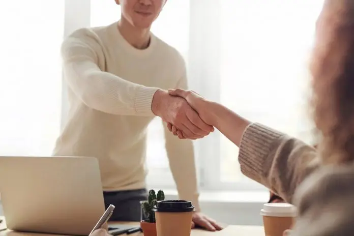 people shaking hands in office