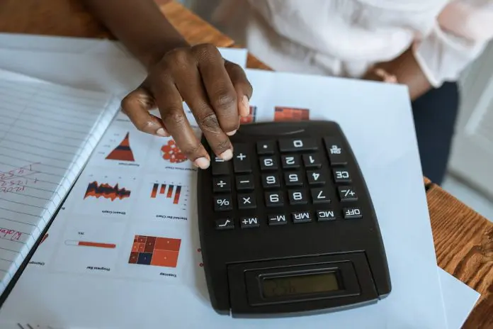 pexels-rodnae-productions-5915236 person using calculator over sheet of data