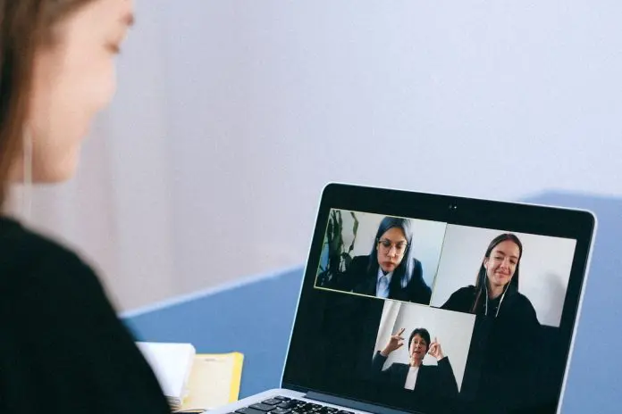 person taking part in online group call on laptop