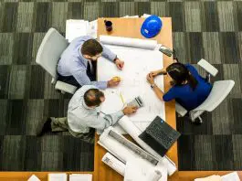 3 people reviewing plans at a table