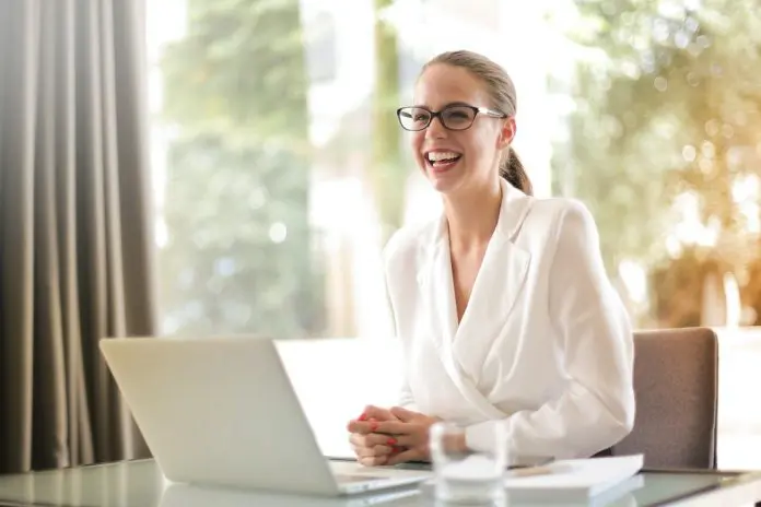 pexels-andrea-piacquadio-3756679 lady in white shirt sitting at laptop, smiling widely