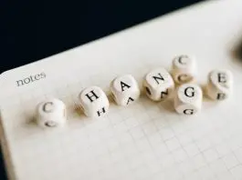 "change" spelled out in scrabble type tiles in top of a notepad