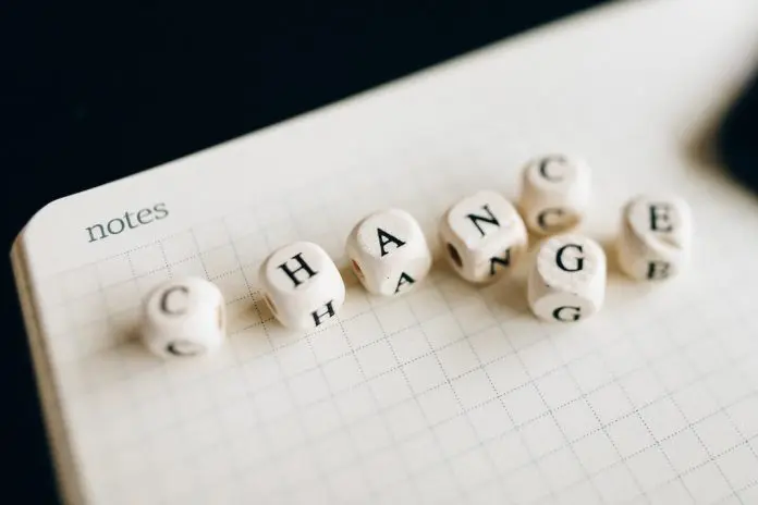 "change" spelled out in scrabble type tiles in top of a notepad