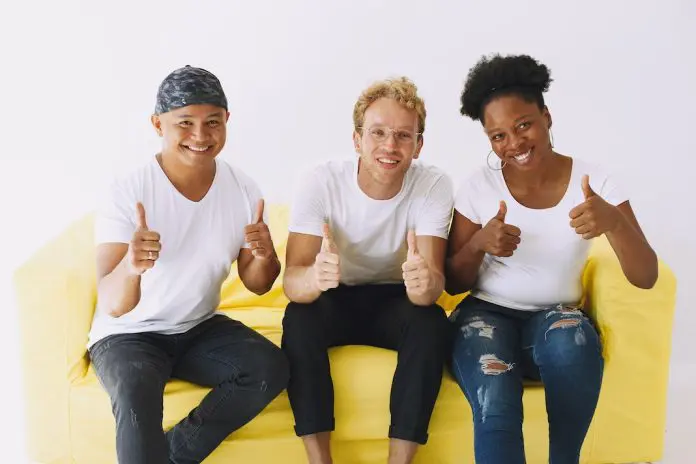 pexels-gustavo-fring-5622557 3 people sitting on yellow sofa with big smiles giving a thumbs up
