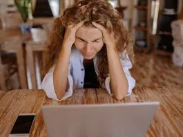 lady with head in hands at desk looking frustrated