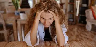 lady with head in hands at desk looking frustrated