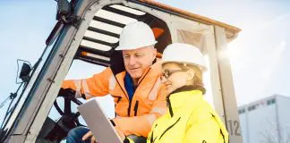 manager discussing logistics with forklift driver