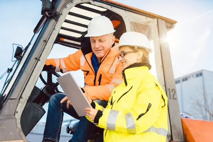 HRHQ Supply Chain manager discussing logistics with forklift driver
