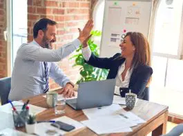 man and woman high fiving in office