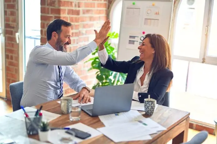krakenimages-376KN_ISplE-unsplash man and woman high fiving in office