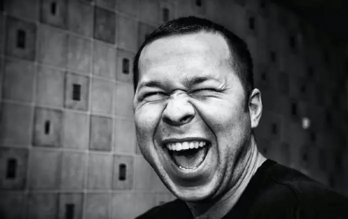 denis-agati--5Vl9oimYlU-unsplash black and white photo of man smiling broadly