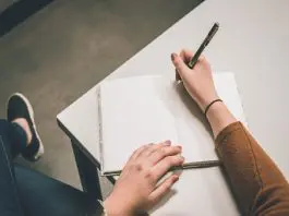 someone about to start writing on a blank page of notebook