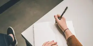 someone about to start writing on a blank page of notebook