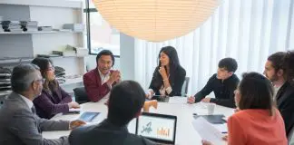 group in deep discussion around round conference table