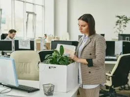 dark haired lady packing her office belongings into a box