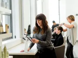 lady looking at tablet in hair dressoing salon