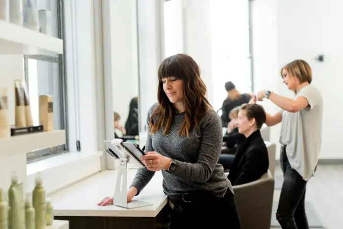 adam-winger--THiqda3iGM-unsplash lady looking at tablet in hair dressoing salon