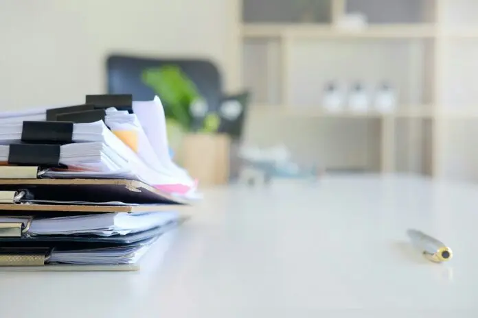 stack of papers and files on a desk