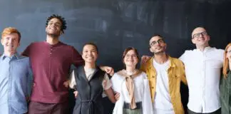 group of happy employees with their arms around each other in a line