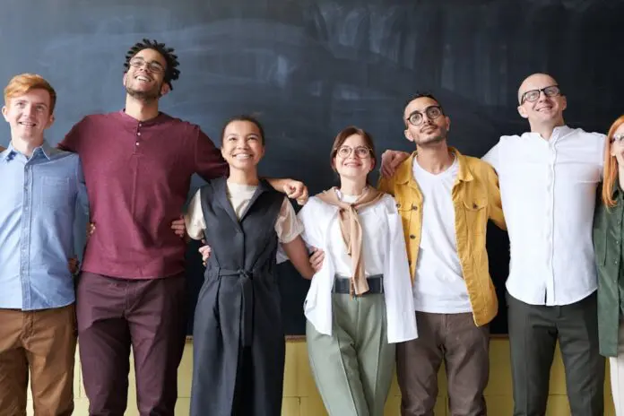 group of happy employees with their arms around each other in a line