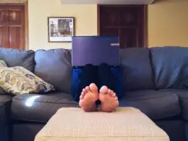 Person Sitting on Couch While Using Laptop Computer