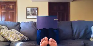 Person Sitting on Couch While Using Laptop Computer
